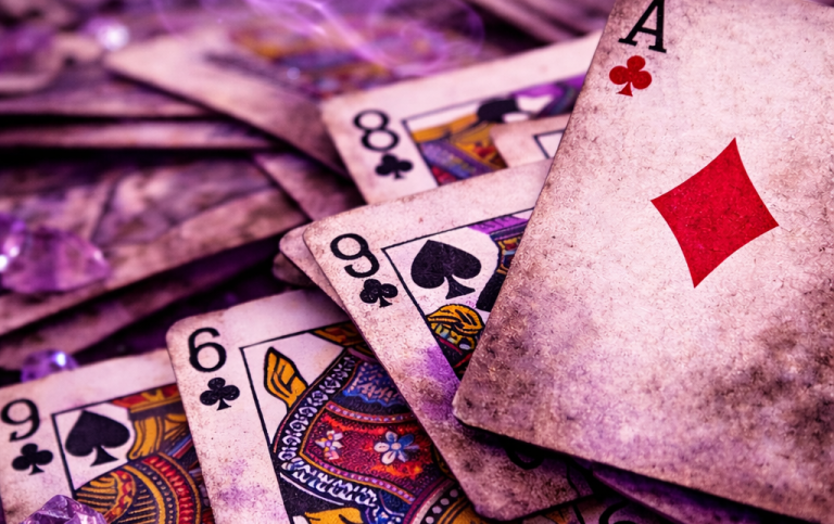 Zeigt andere Orakelkarten Spielkarten, darunter ein Ass mit rotem Diamanten, auf einem ungeordneten Tisch verteilt.